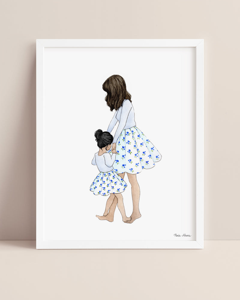 Mother daughter watercolor art print displayed in a white picture frame on a neutral background